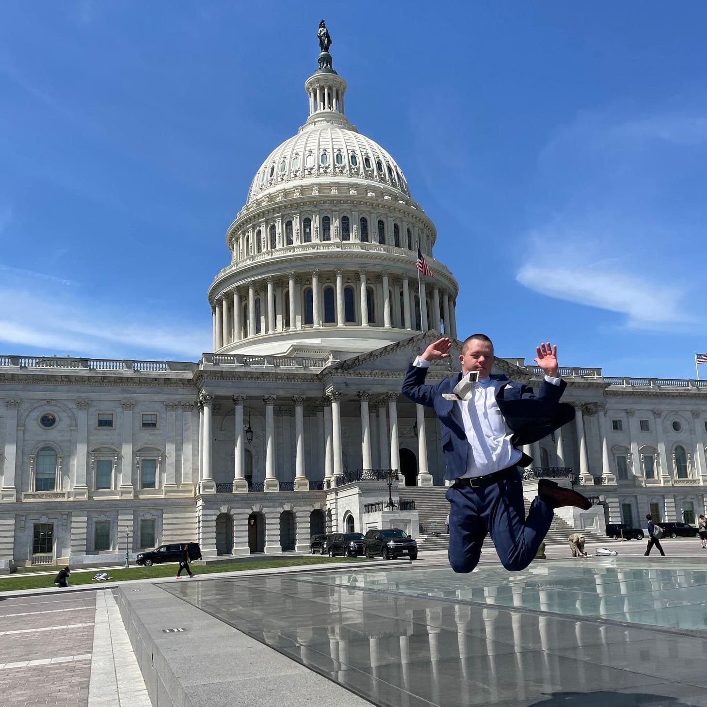 Man jumping up in the air in front of the Capitol building in Washington, DC